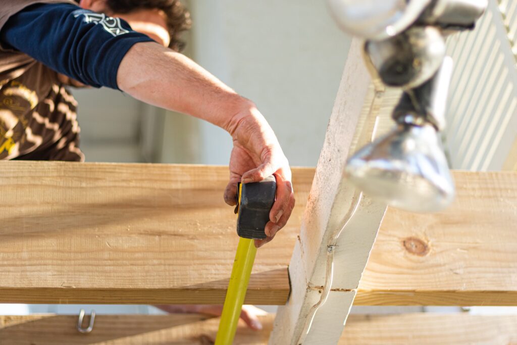 Man Measuring the Roof Wood with Measuring Tape